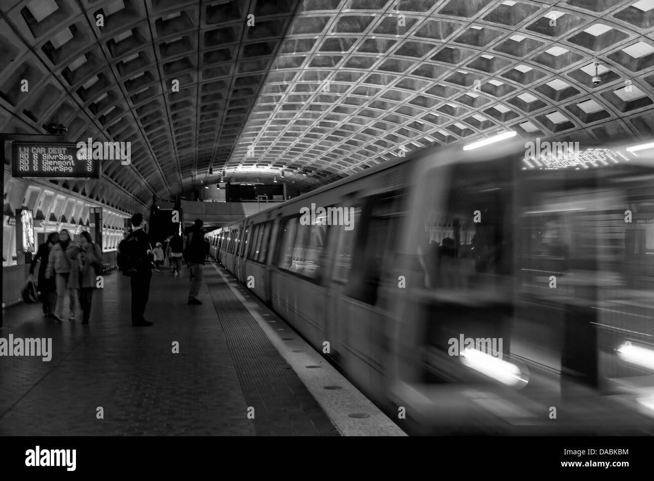La metropolitana treno passa attraverso una stazione della metropolitana a Washington D.C. Pendolari attendere sulla piattaforma per esso. Foto Stock