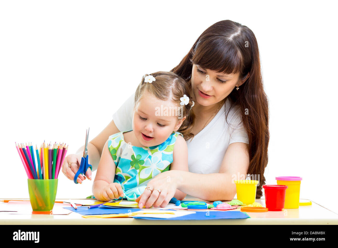 La madre e il bambino disegnare e tagliare insieme Foto Stock