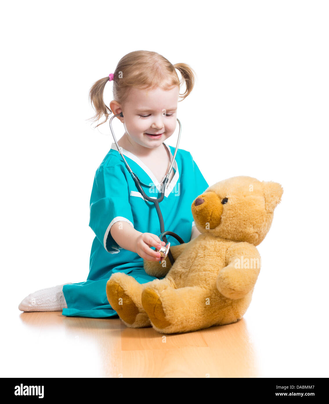 Bambino ragazza con vestiti di dottore giocare con il giocattolo di peluche Foto Stock