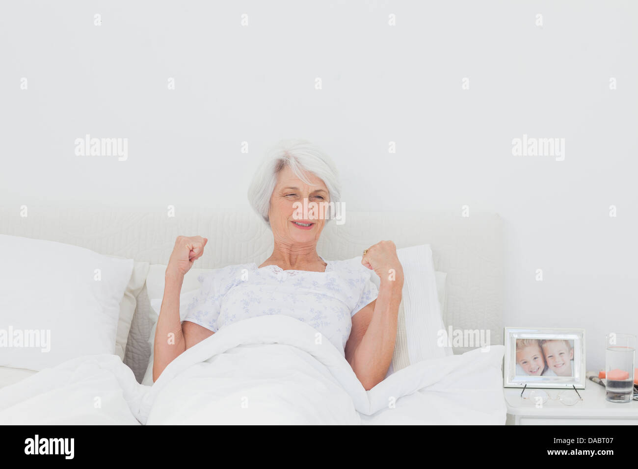 Donna stretching e bracci di sollevamento a letto Foto Stock