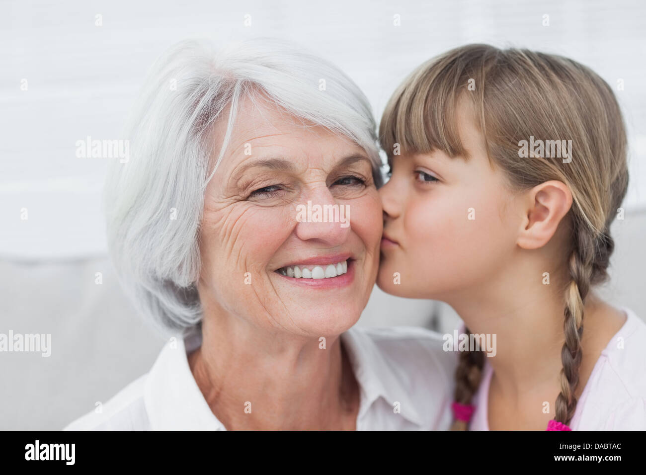 Incantevole piccola ragazza baciare la nonna Foto Stock