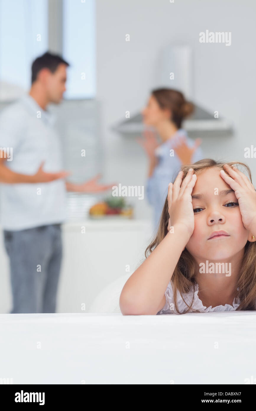 Ragazza infastiditi mentre ascoltate i genitori quarreling Foto Stock