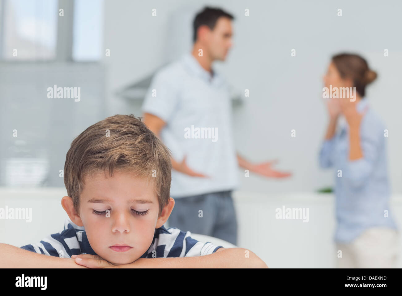 Triste ragazzo mentre i genitori quarreling Foto Stock