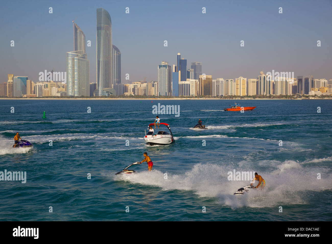 Vista della città dalla Marina e getto sci sport d'acqua, Abu Dhabi, Emirati Arabi Uniti, Medio Oriente Foto Stock