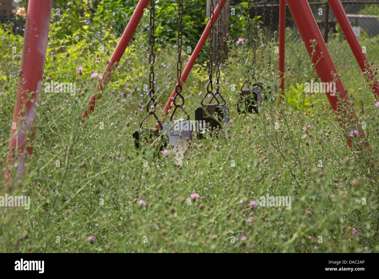 Hamtramck, Michigan - un parco giochi nelle erbacce al parco dei veterani. La città è in emergenza finanziaria. Foto Stock
