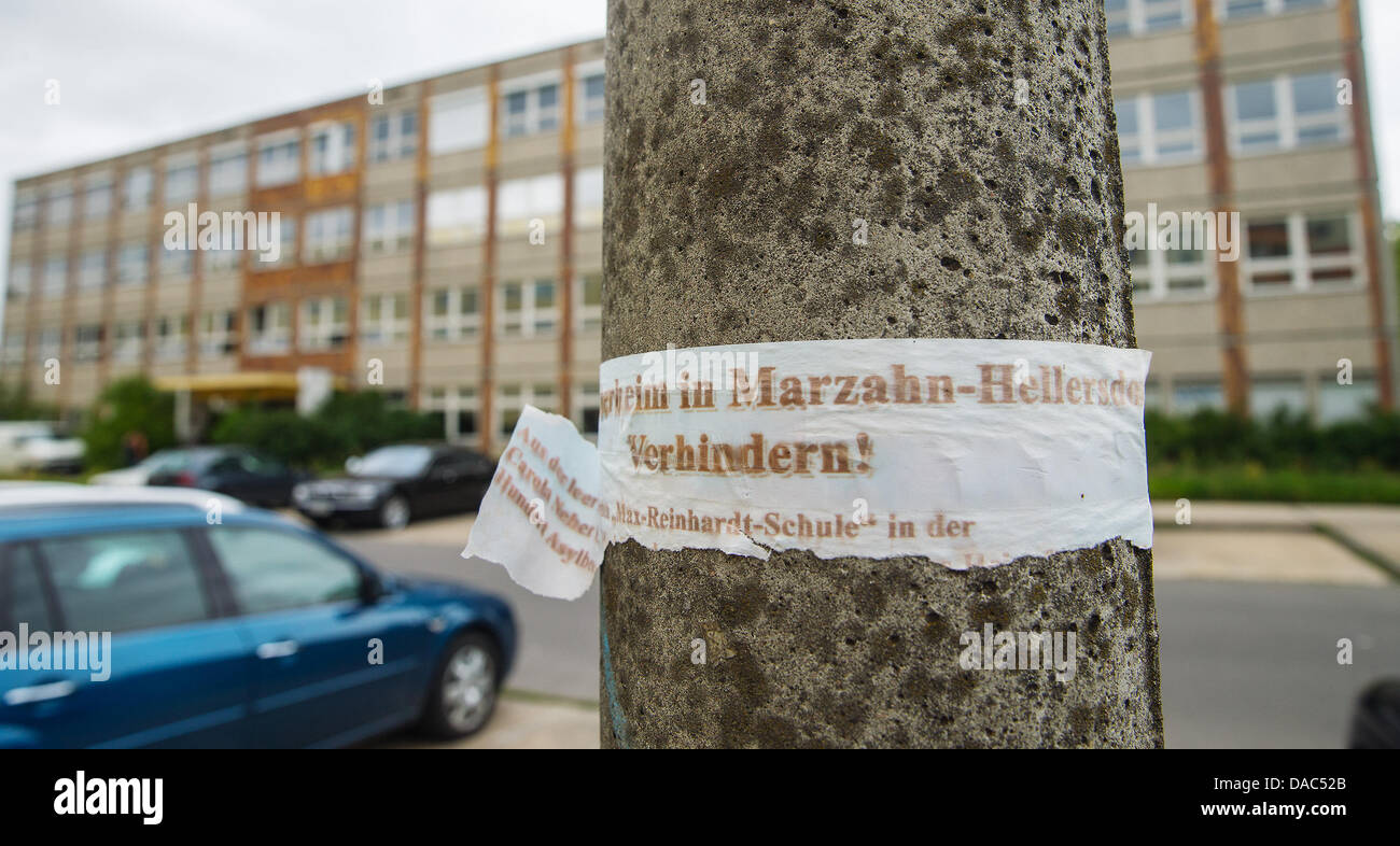 Una lettura della carta "Asylbewerberheim in Marzahn-Hellersdorf verhindern!' ('evitare che i richiedenti asilo house di Marzahn-Hellersdorf') è inviato a una lanterna di fronte alla prevista rifugio di fortuna per i rifugiati a Berlino Marzahn-Hellersdorf a Berlino, Germania, 10 luglio 2013. Il previsto ricovero causato forti polemiche negli ultimi giorni. Foto: HANNIBAL HANSCHKE Foto Stock