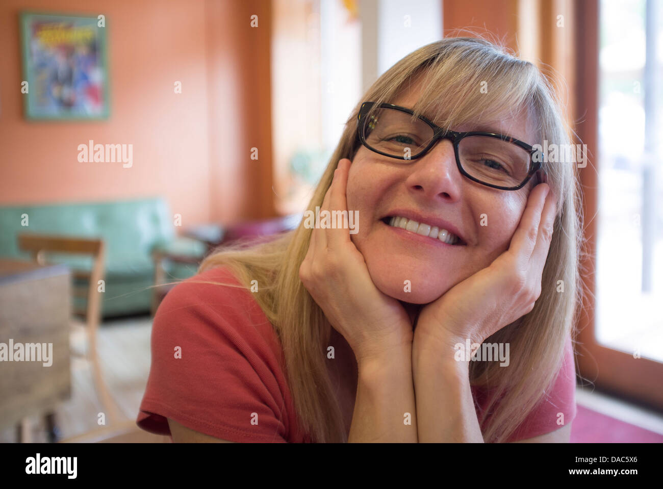 Primo piano della donna con sorridente, espressione piacevole guardando la fotocamera. Foto Stock