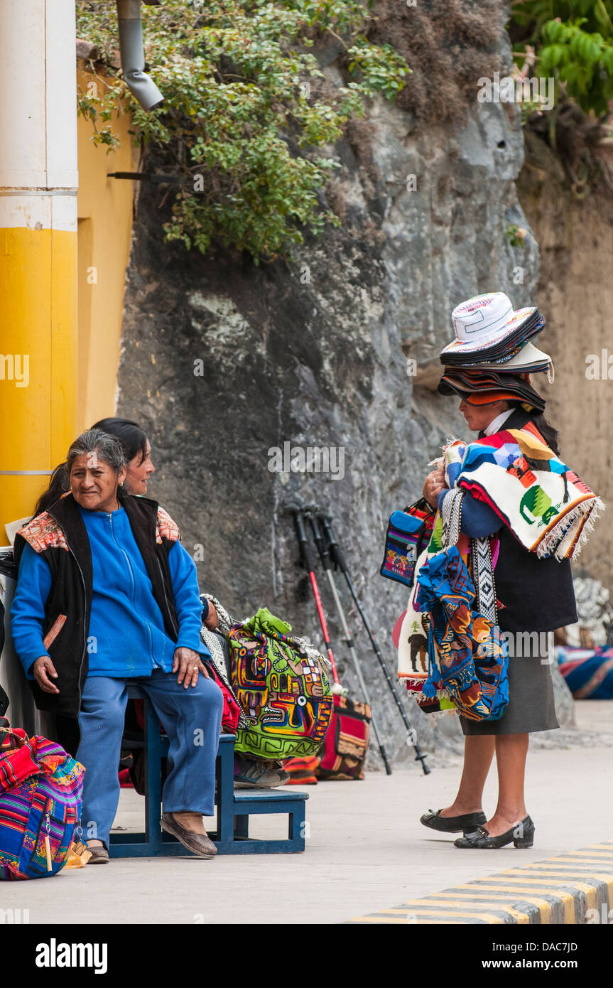 I venditori di souvenir in attesa per i treni auto carrello al Ollanta stazione dei treni di Ollantaytambo, Valle Sacra, Perù. Foto Stock