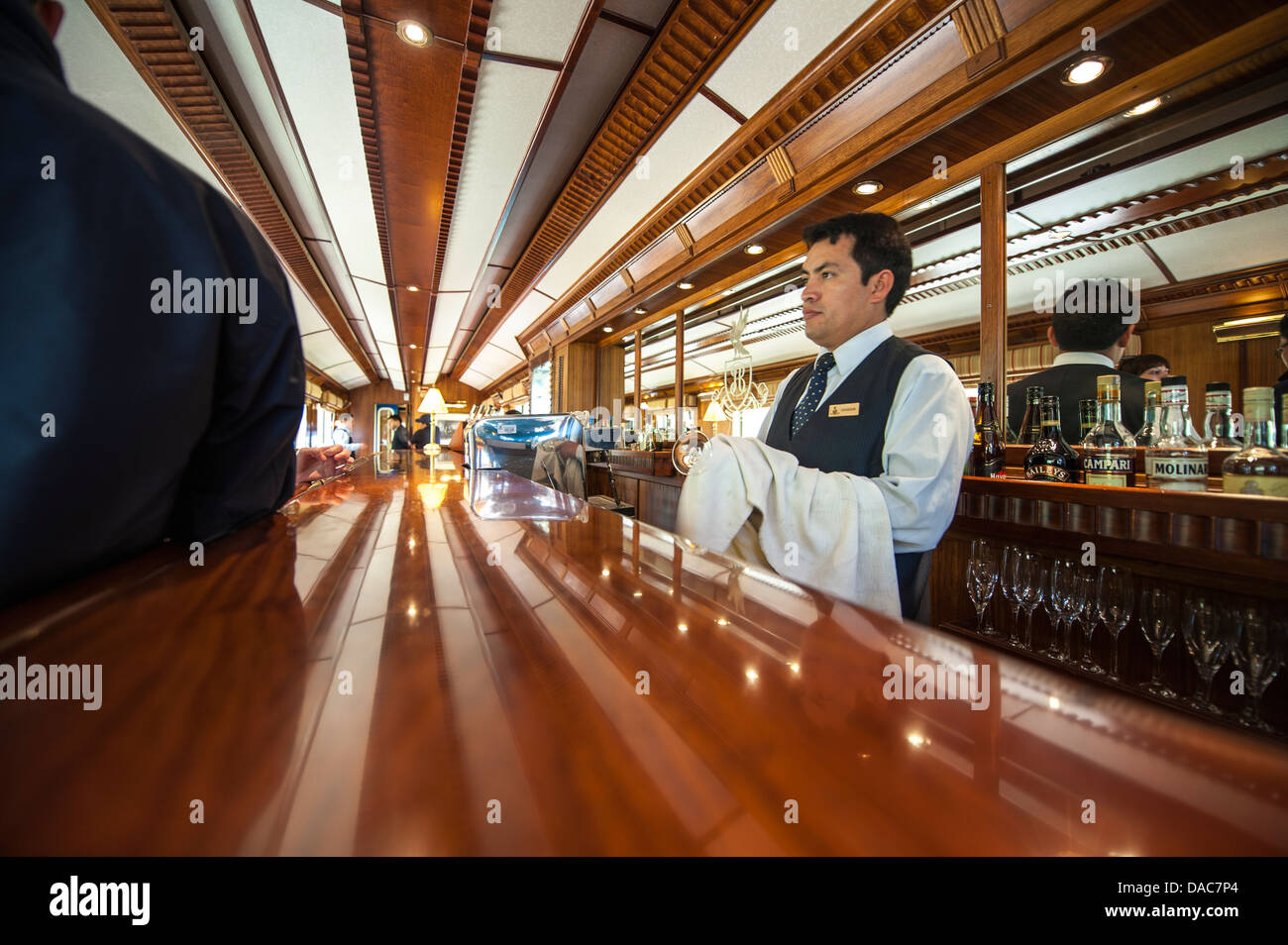 Barman nel bar auto a bordo di un treno Hiram Bingham carrello auto nei pressi di Ollantaytambo, Valle Sacra, Perù. Foto Stock