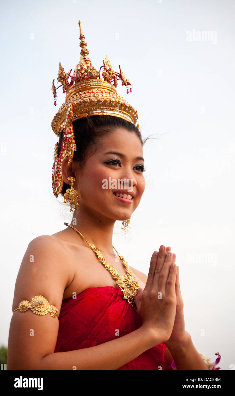 Giovane donna Thai in costume tradizionale e le mani insieme a 'Wai' saluto pongono; al Siam Niramit; Bangkok, Tailandia. Foto Stock