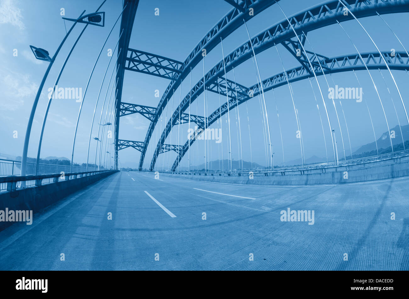 La strada attraverso il ponte con cielo blu sullo sfondo di una città Foto Stock