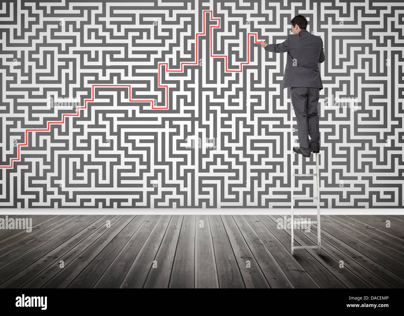 Imprenditore in piedi su una scala risolvendo puzzle maze Foto Stock