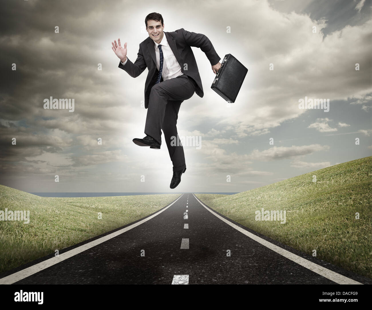 Imprenditore saltando su una strada Foto Stock