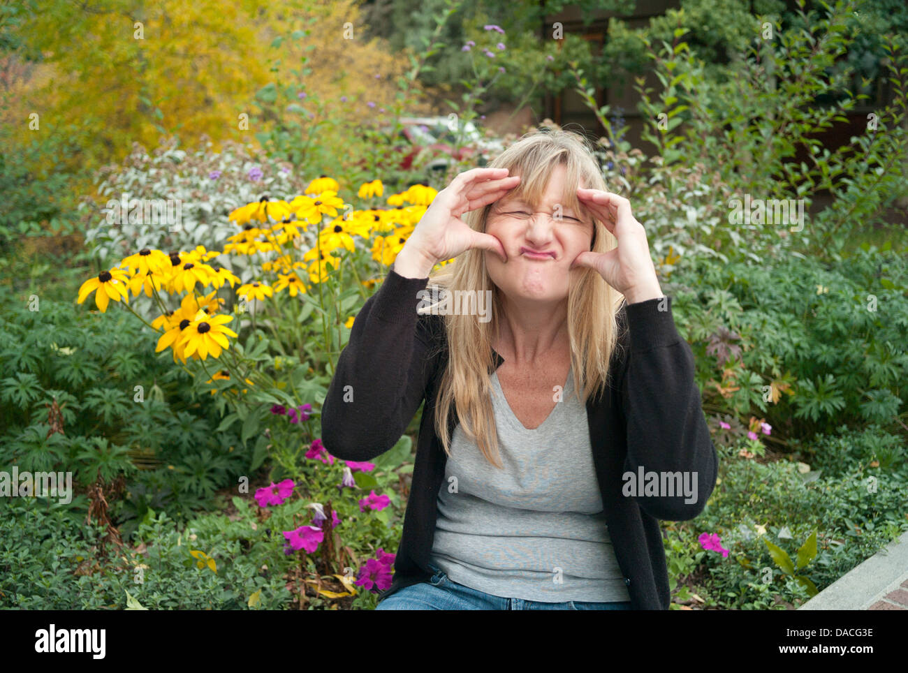 Donna che fa una faccia di Pippo. Foto Stock