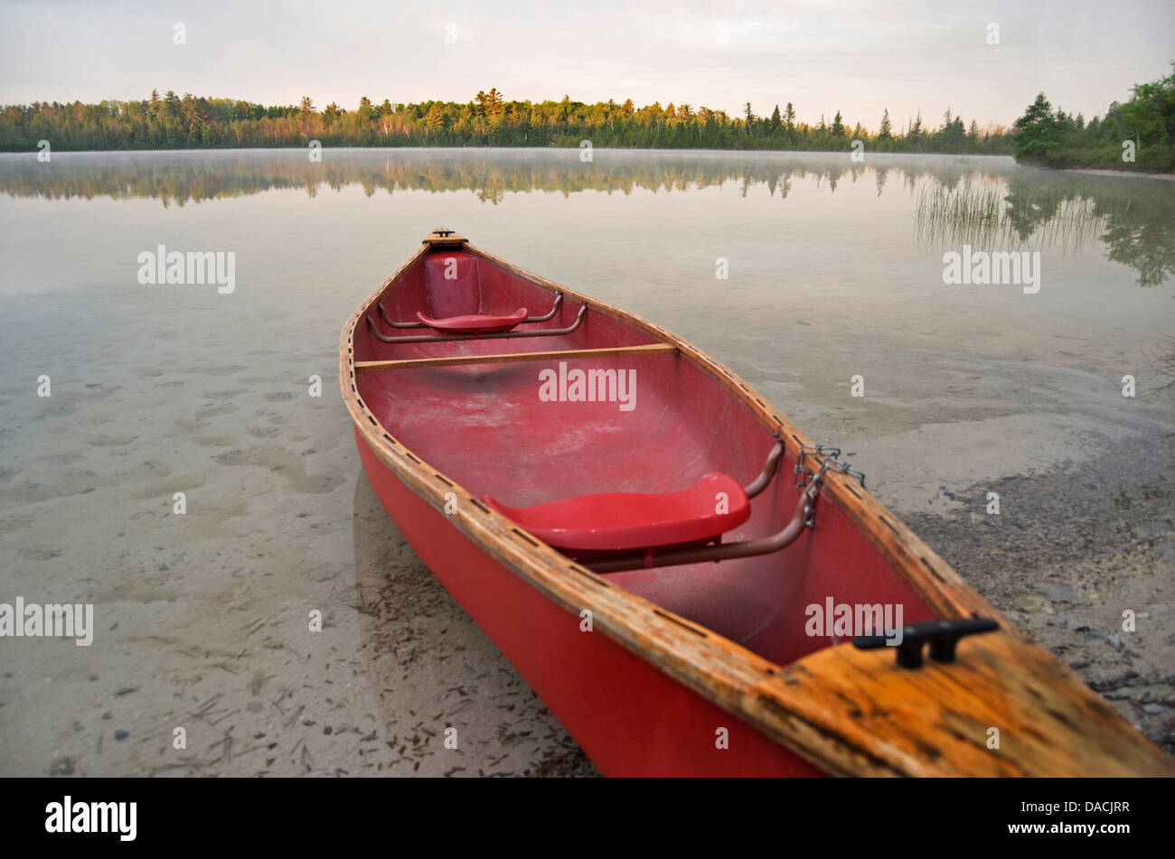 Rosso ancorato canoa in piccolo entroterra del lago al mattino. Foto Stock