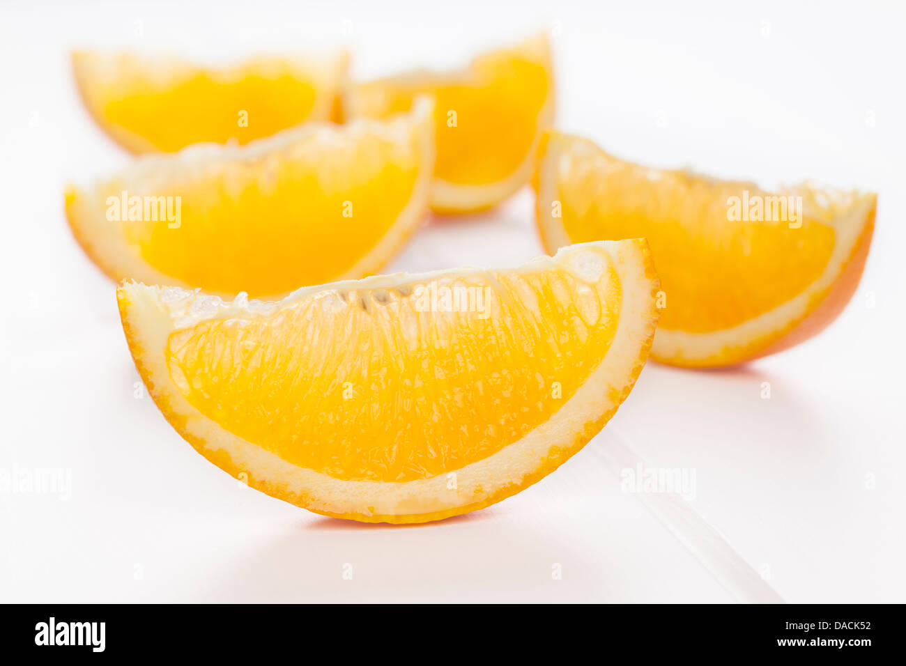 Spicchi d'arancia o le fette su uno sfondo bianco con le ombre morbide. Foto Stock