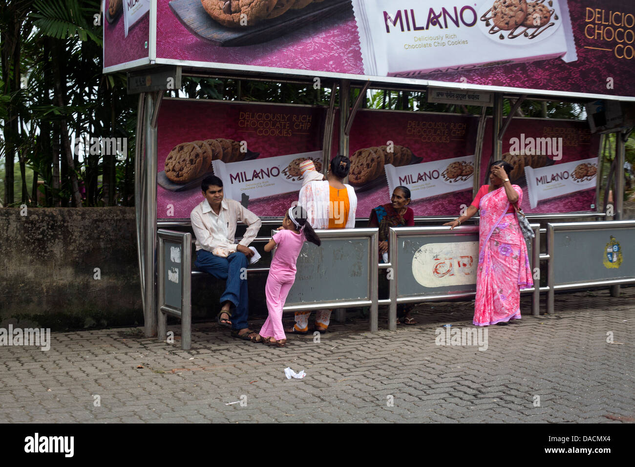 Le persone in attesa del bus alla fermata in rosa Foto Stock