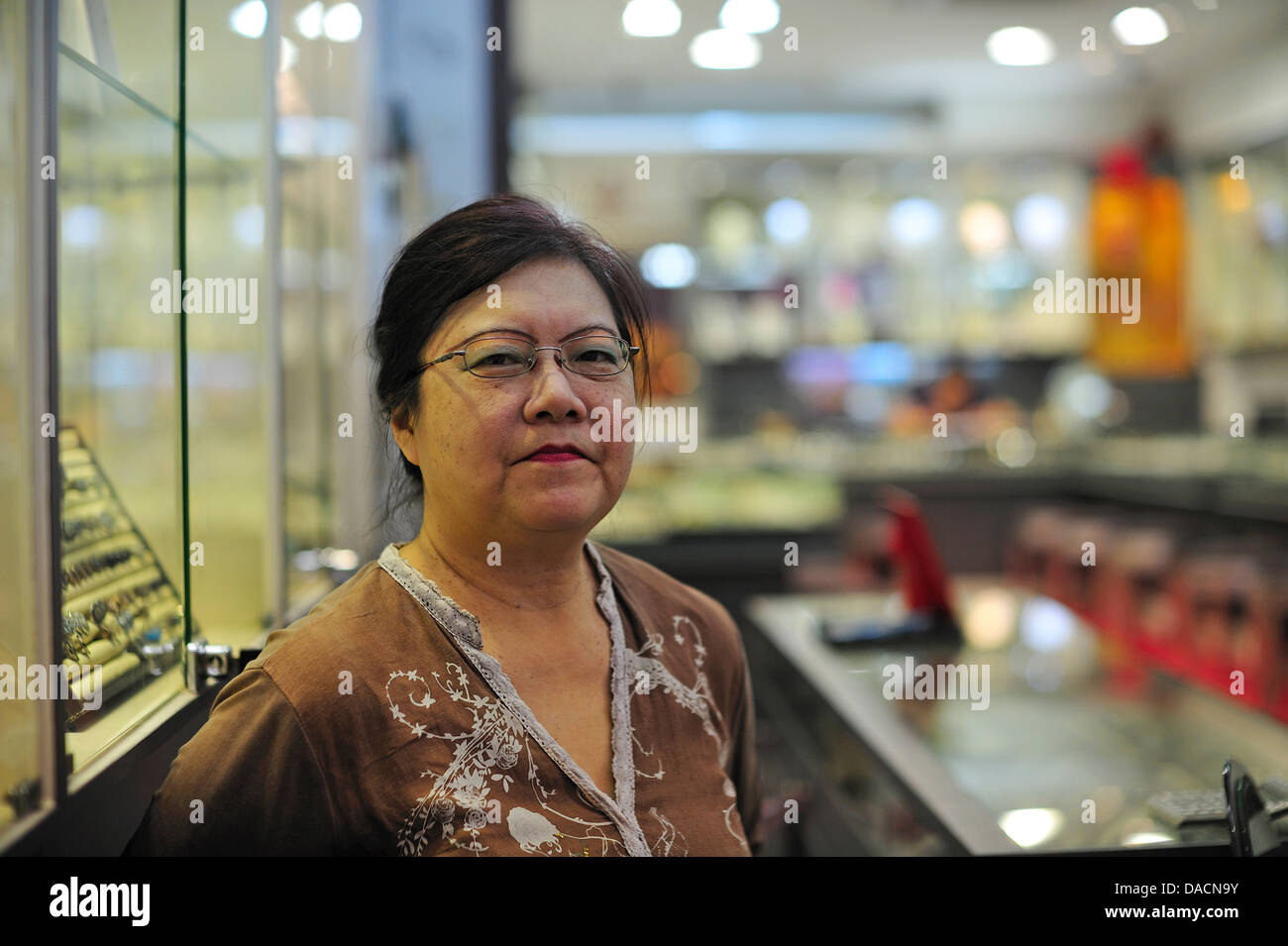 Signora lavora in Myer il negozio Gioielli Chinatown di Singapore Foto Stock