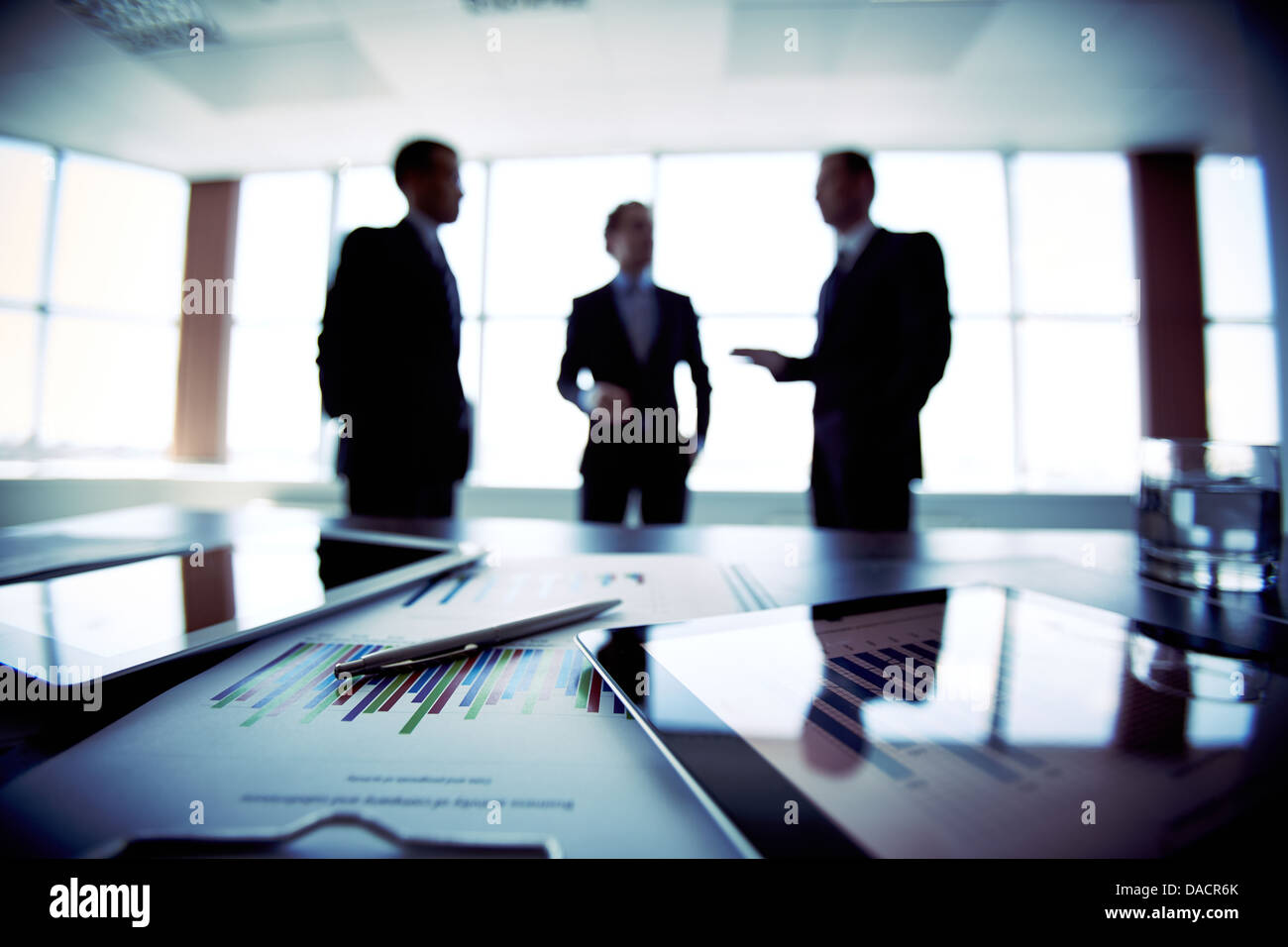 I colleghi riuniti per discutere i loro futuri piani finanziari, solo sagome essendo visualizzati Foto Stock