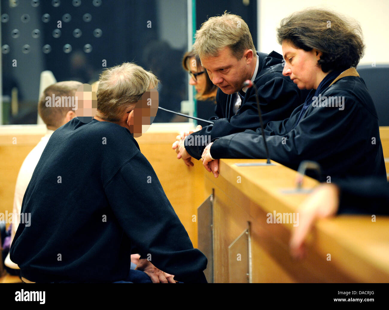 La convenuta Adolf B. (L, 56) parla ai suoi avvocati Holger Nitz e Angelika Bock (R-L) prima del suo processo presso il tribunale di stato di Hannover, Germania, 13 dicembre 2011. La Corte ha condannato Adolf B. e Andrej L. a vita in prigione per l'omicidio di un timbro concessionario. Un terzo coinvolto, Vadyn C. (back-L), è stato condannato a 3 anni e mezzo in carcere. Il condannato il trio aveva attaccato il 53-anno-vecchio f Foto Stock