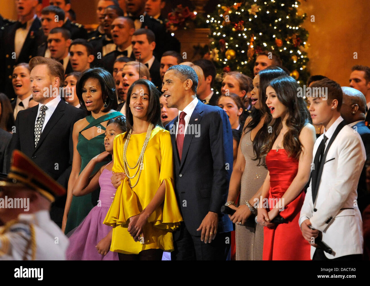 Il Presidente degli Stati Uniti Barack Obama (C), la first lady Michelle Obama e le figlie Malia e Sasha sono unite da animatori (L-R) Conan O'Brien, Jennifer Hudson, Victoria Giustizia e Justin Bieber per un canto finale alla conclusione delle esibizioni presso l'annuale "Natale in Washington' gala, Dicembre 11, 2011, Washington, DC. Credito: Mike Theiler / Pool via CNP Foto Stock