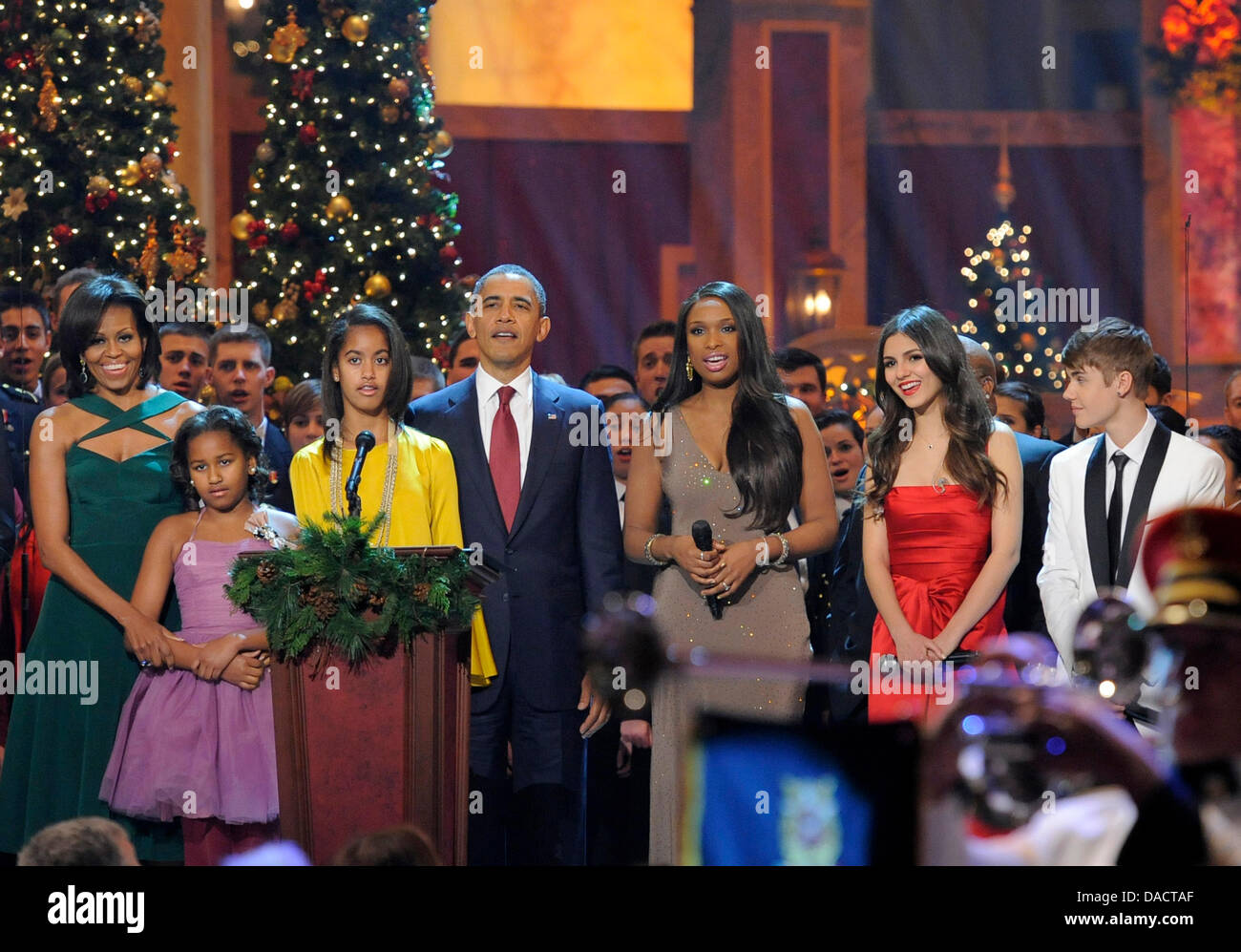 Il Presidente degli Stati Uniti Barack Obama (C), la first lady Michelle Obama e le figlie Malia e Sasha sono unite da animatori (L-R) Jennifer Hudson, Victoria Giustizia e Justin Bieber per un canto finale alla conclusione delle esibizioni presso l'annuale "Natale in Washington' gala, Dicembre 11, 2011, Washington, DC. Credito: Mike Theiler / Pool via CNP Foto Stock