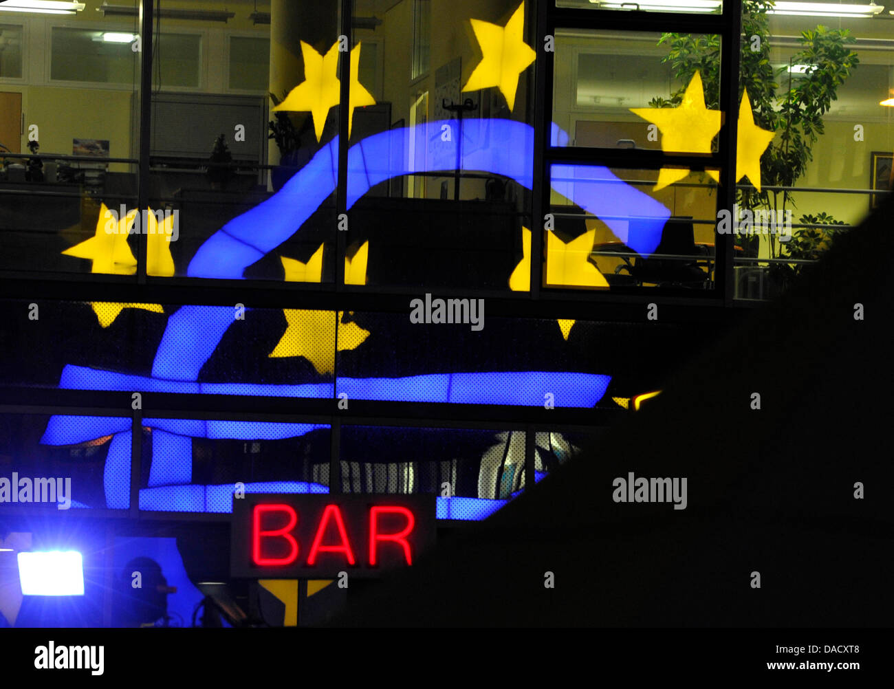 Il simbolo dell'euro viene riflessa sulla facciata di vetro di un edificio al di sopra di un rosso contrassegnate da lettere e segno di un bar di fronte alla Banca centrale europea (BCE) di Francoforte sul Meno, Germania, 21 dicembre 2011. Secondo la BCE, numerose banche della zona euro la quaresima 489 miliardi di euro tutti insieme dalla Banca centrale europea. Il 22 dicembre 2011, esperti finanziari desiderano discutere la situazione attuale Foto Stock