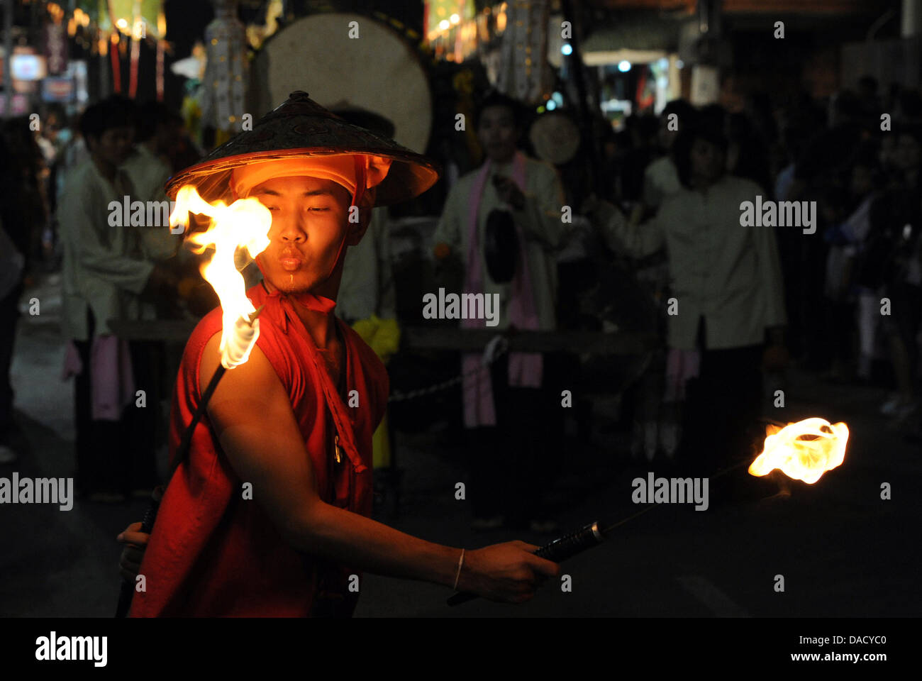 Persone vestite nei tradizionali costumi Thai danza e destreggiarsi con il fuoco in una sfilata durante la festa delle luci Loy Krathong a Chiang Mai, Thailandia, 10 novembre 2011. Il festival è celebrato in tutto il paese durante la luna piena del dodicesimo mese dell'anno e proviene da una tradizione indù. Foto: Jens Kalaene Foto Stock