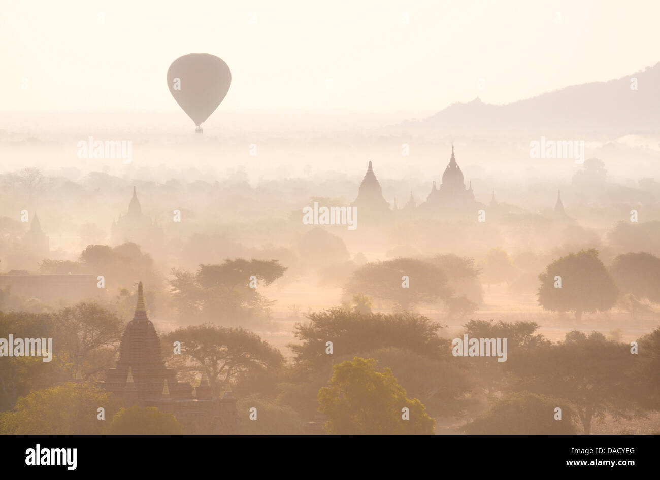Templi di Bagan immersa nella nebbia di mattina, con una mongolfiera alla deriva tutta la scena, dalla Shwesandaw Paya, Bagan, Myanmar Foto Stock