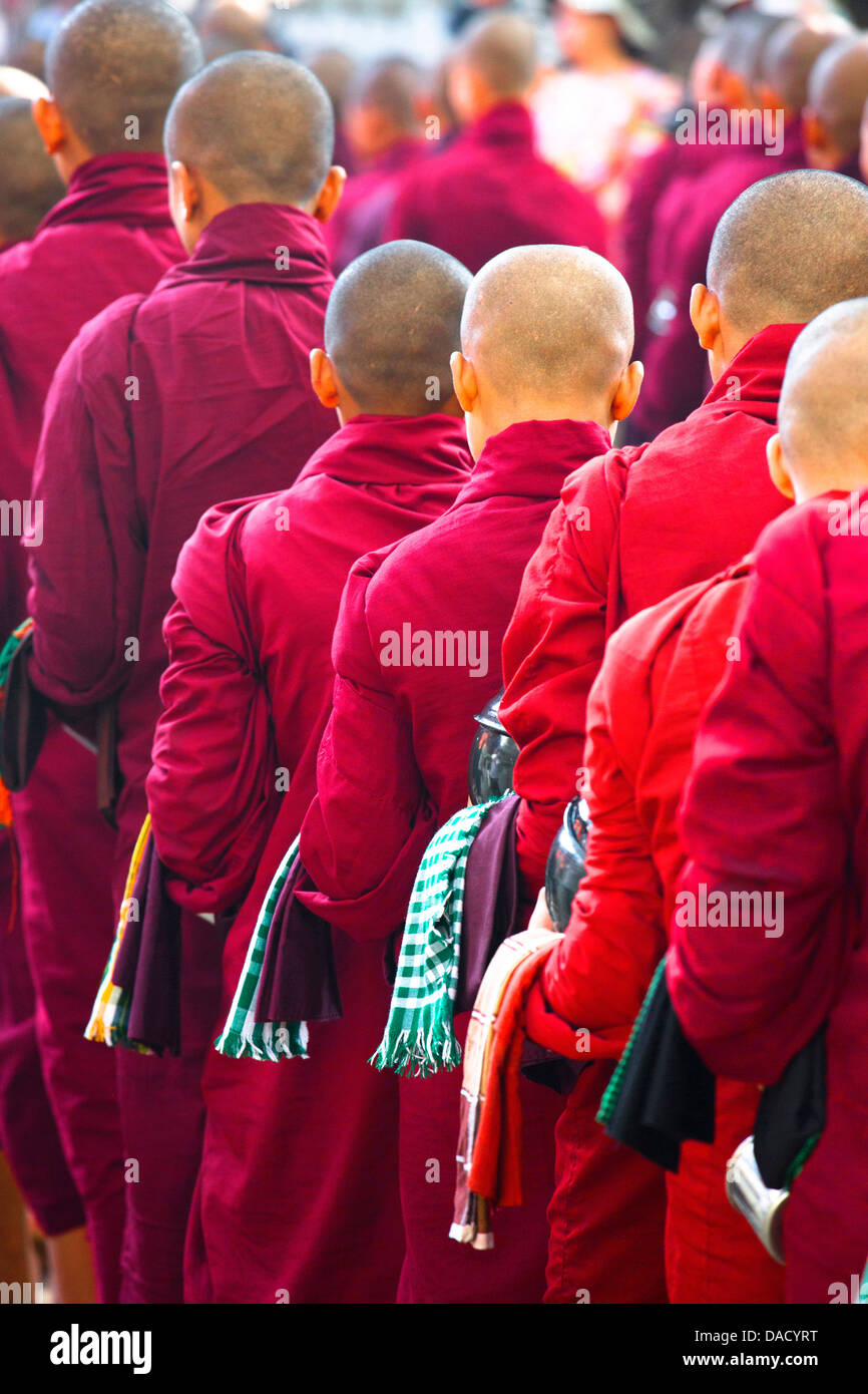I monaci buddisti in coda per un pasto al monastero Mahagandayon, dove 2000 monaci sono alimentati quotidianamente, Mandalay Myanmar Foto Stock