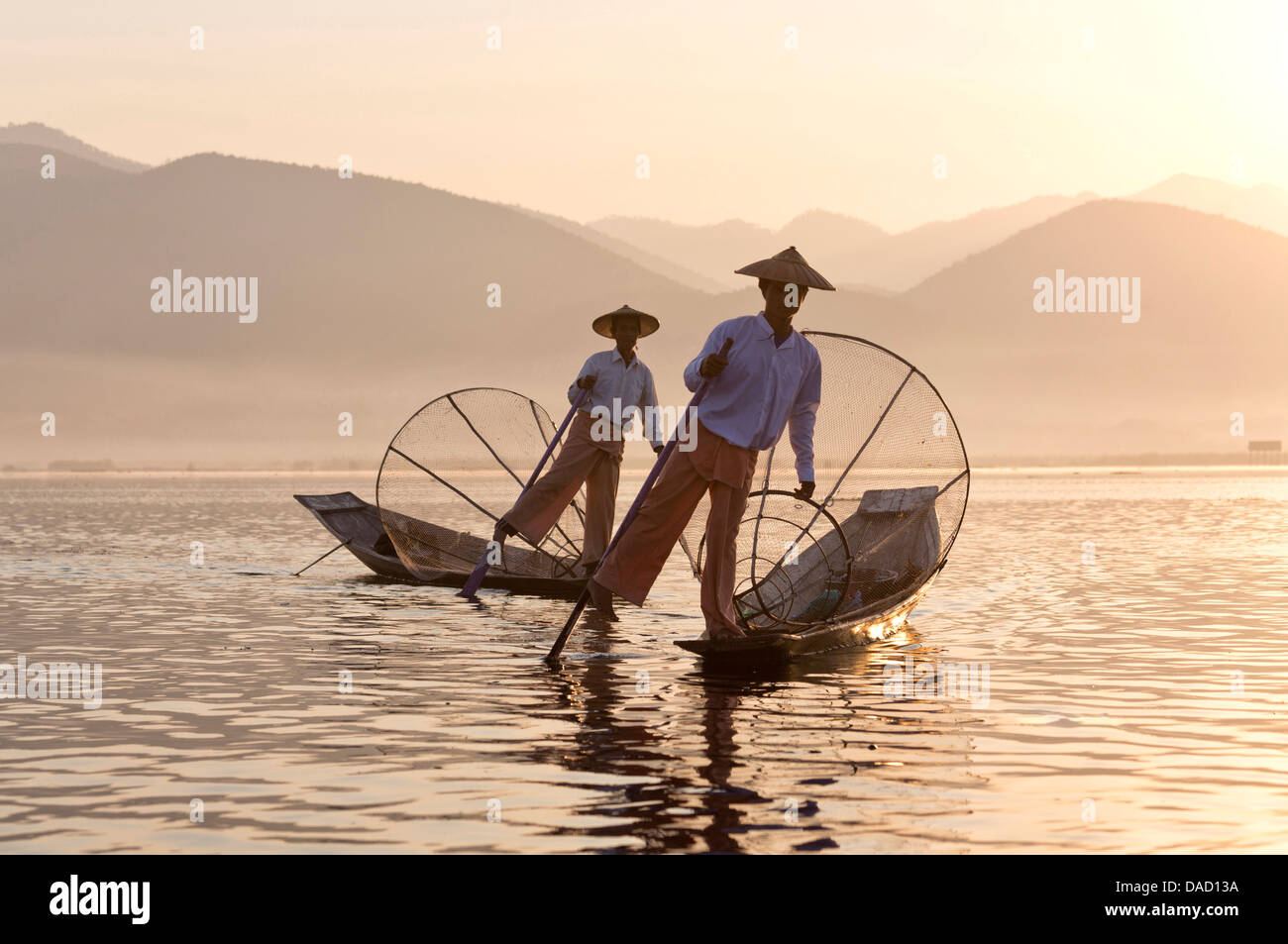 Intha "gamba" a remi dei pescatori al tramonto sul Lago Inle, Lago Inle, Myanmar Foto Stock