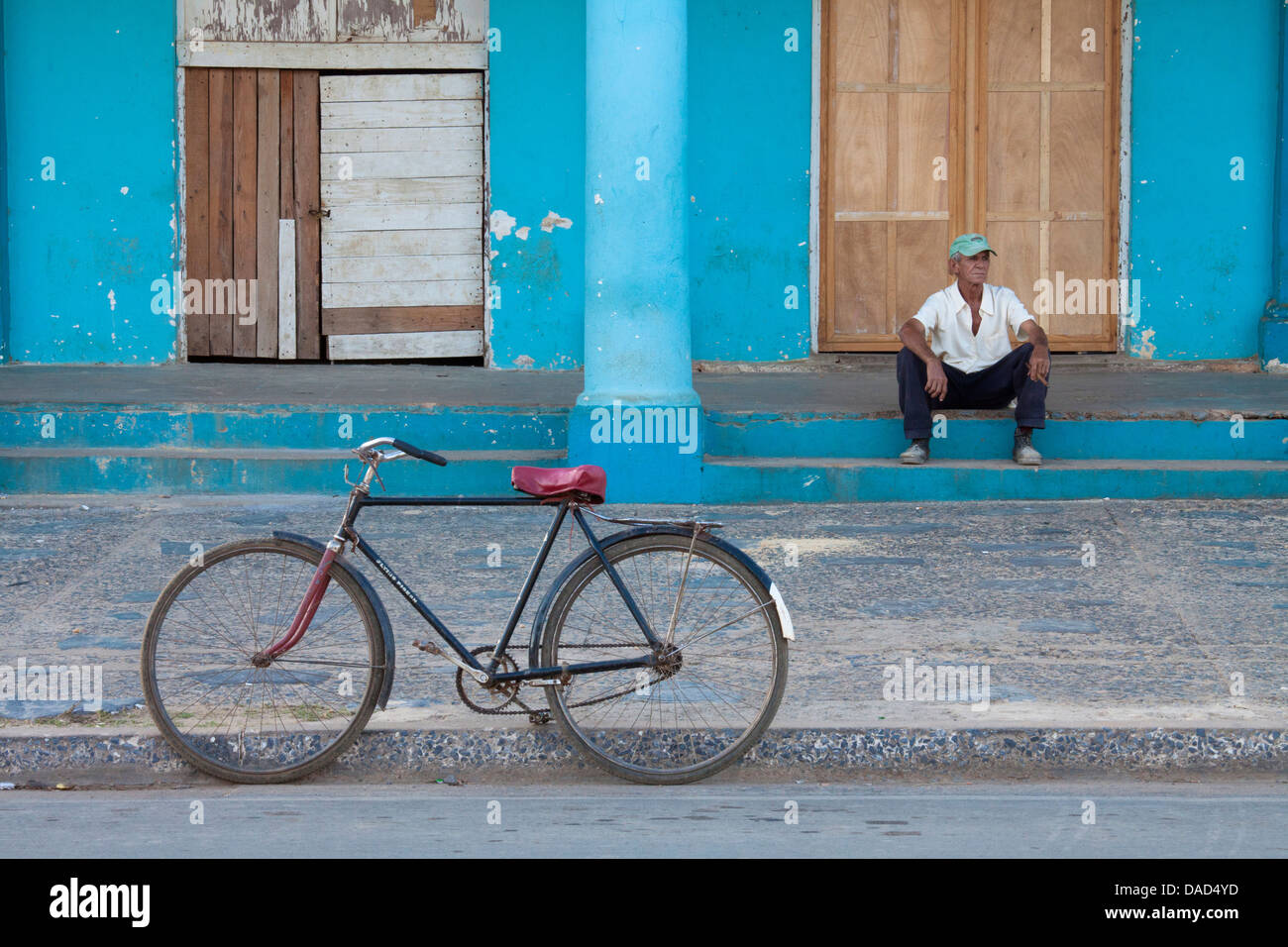 Propped in bicicletta fino al di fuori del vecchio edificio con uomo locale sui gradini, Vinales, Pinar Del Rio Provincia, Cuba, West Indies Foto Stock