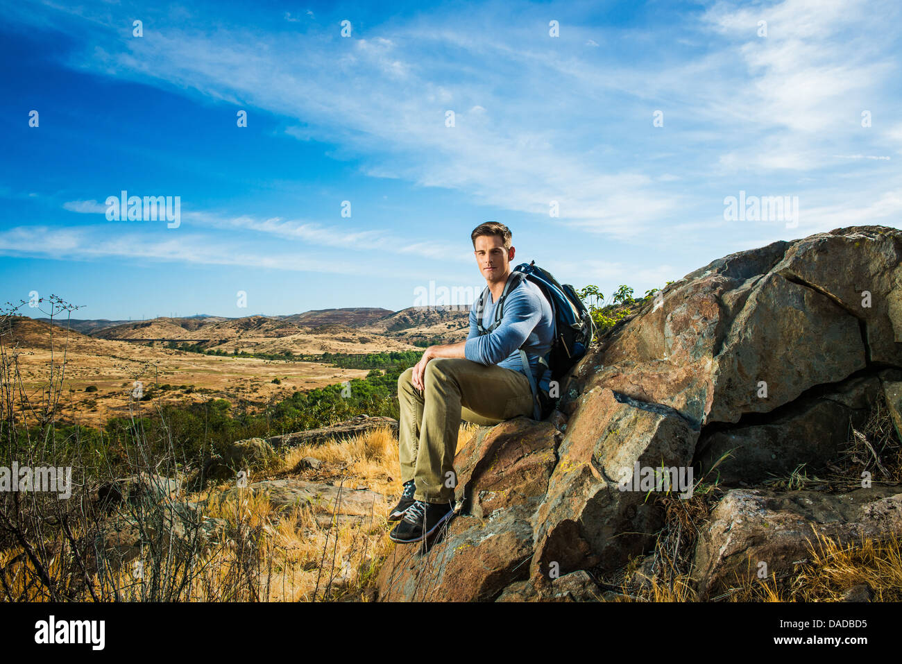 Escursionista maschile seduto su roccia Foto Stock