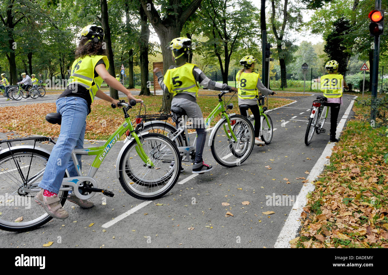 La scuola dei bambini ride su biciclette durante una lezione pratica presso i bambini del centro di formazione per il traffico a Colonia, Germania, il 4 ottobre 2011. I 104 centri di formazione di stato del Land Renania settentrionale-Vestfalia apportare un importante contributo alla sicurezza del traffico educazione dei bambini. Sotto la supervisione di personale specializzato, i bambini imparano con le biciclette come comportarsi nel normale giorno-per-da Foto Stock