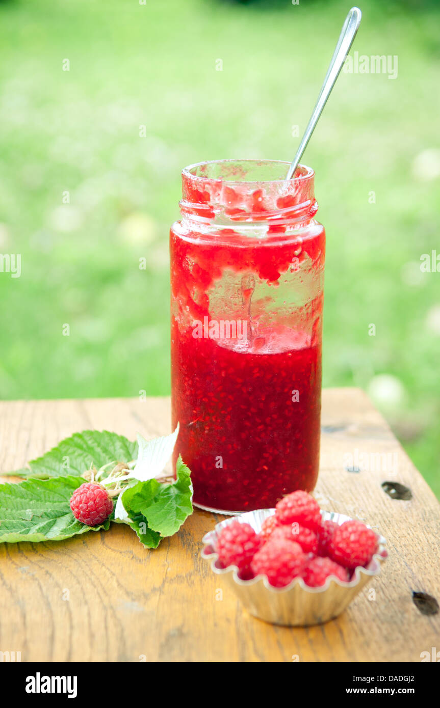 Confettura di lamponi con lamponi freschi sul tavolo di legno Foto Stock
