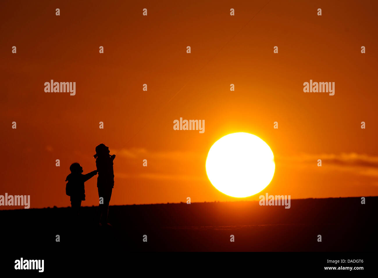 Due bambini di stare di fronte al sole di setting di Essen, in Germania, il 24 ottobre 2011. Foto: MARIUS BECKER Foto Stock