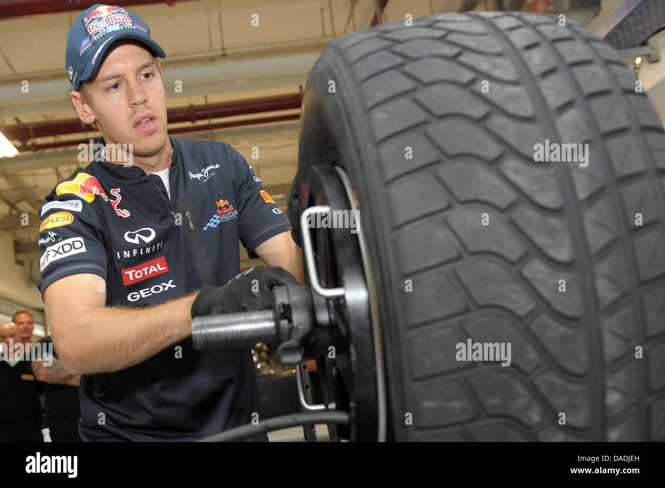 Tedesco di Formula Uno pilota Sebastian Vettel della Red Bull si monta un pneumatico Pirelli al cerchio in una sfida in pista Buddh International Circuit, maggiore noida, India, 27 ottobre 2011. Il primo Gran Premio di Formula Uno di India avrà luogo il 30 ottobre 2011. Foto: David Ebener dpa +++(c) dpa - Bildfunk+++ Foto Stock