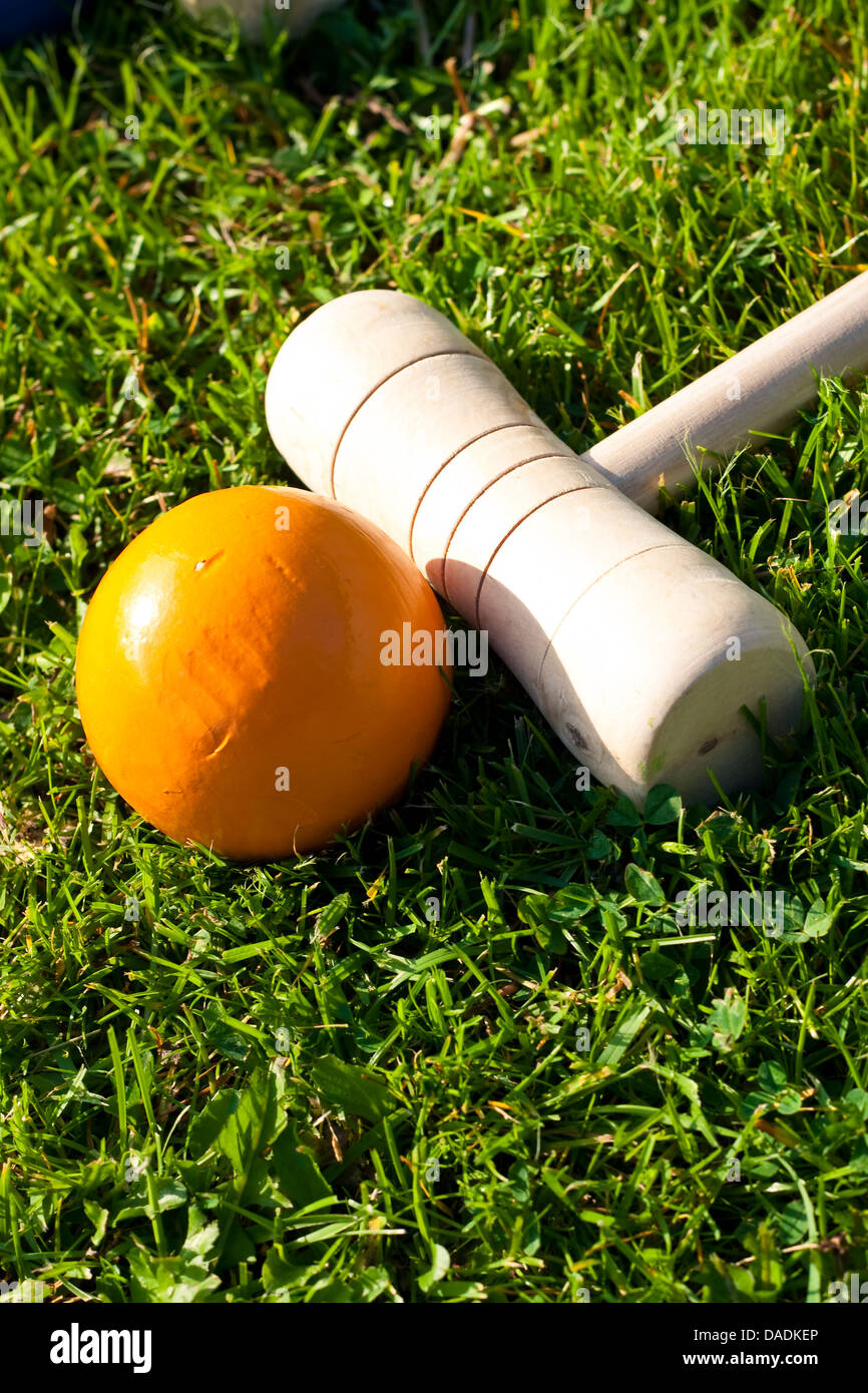 Stick per croquet e sfera gialla a erba verde Foto Stock