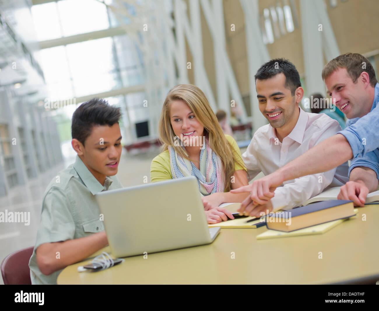 Giovane uomo e studiando con il tutor puntando al laptop Foto Stock