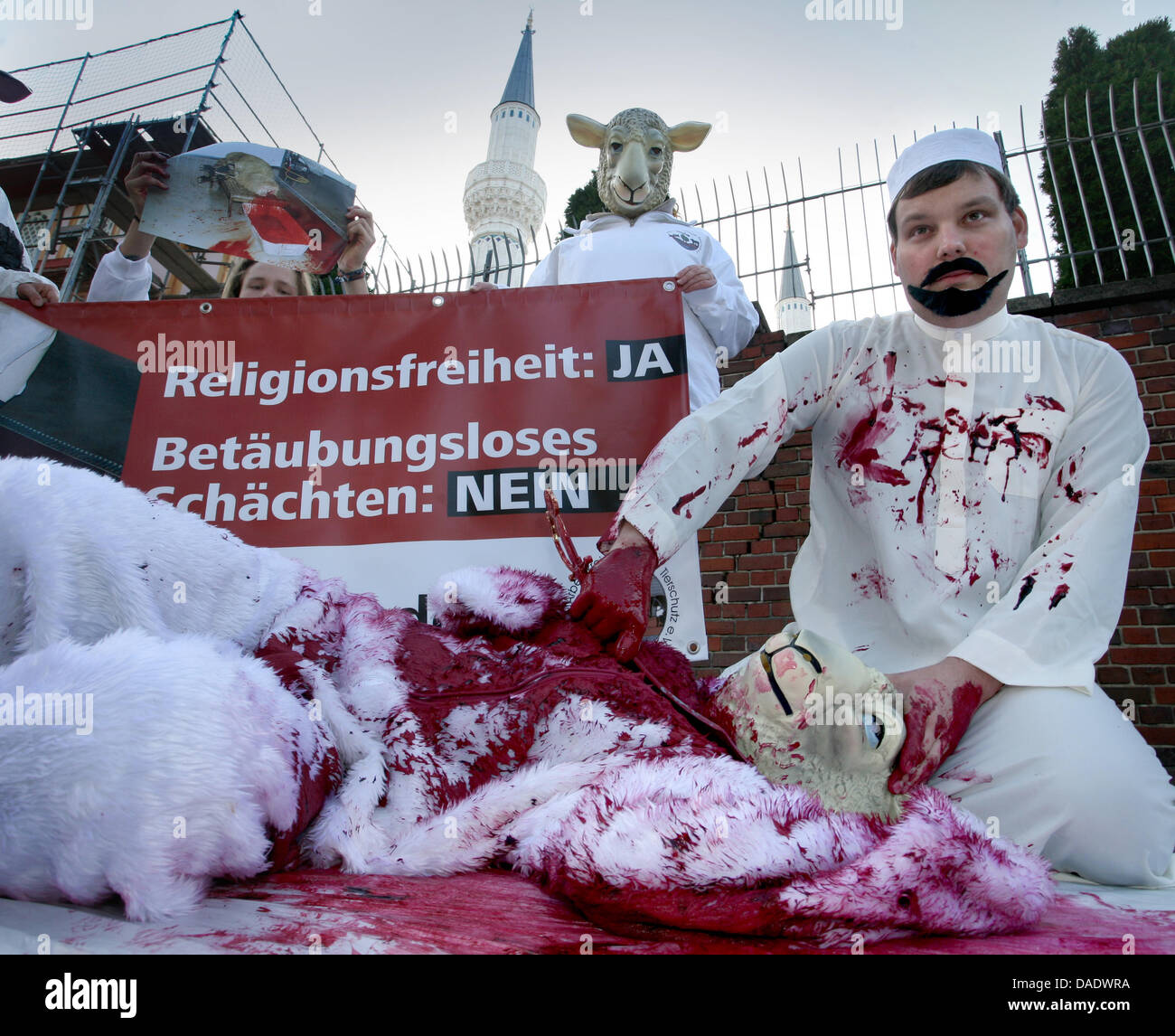 Un membro della "umanità protezione animale associazione' stadi la macellazione degli ovini con un burattino davanti ad una moschea a Berlino, Germania, 03 novembre 2011. I contestatori desidero attirare la vostra attenzione su una tradizione musulmana dove le pecore sono macellati senza anestesia. Un animale tedesco protection act vieta la macellazione senza anestesia, ma riguarda la tradizione religiosa per essere un'eccezione Foto Stock