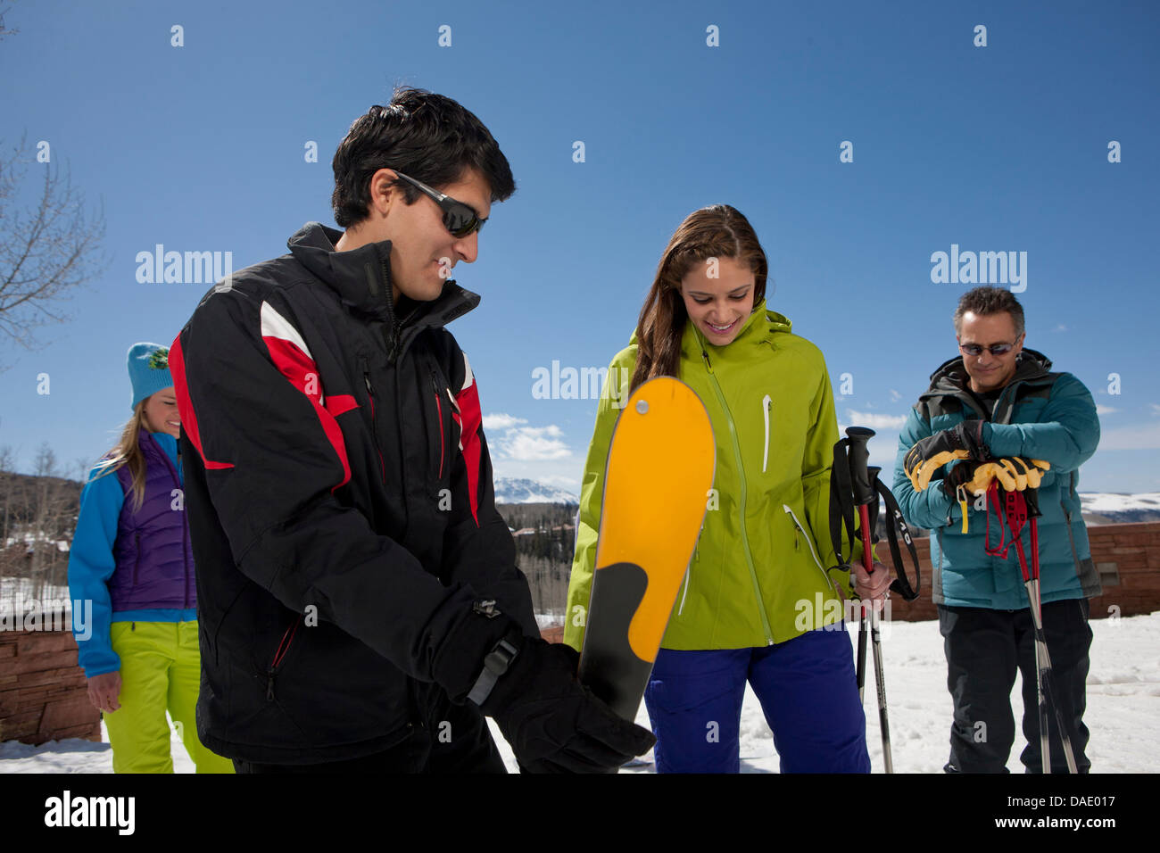 Uomo maturo e giovane donna con maestri di sci su piste da sci Foto Stock