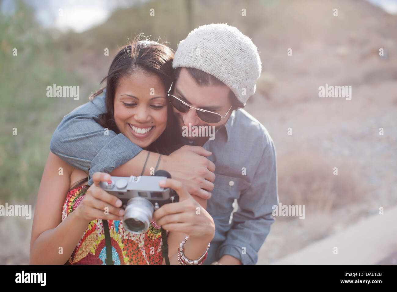 Giovane abbracciando e tenere la fotocamera sul viaggio su strada, sorridente Foto Stock