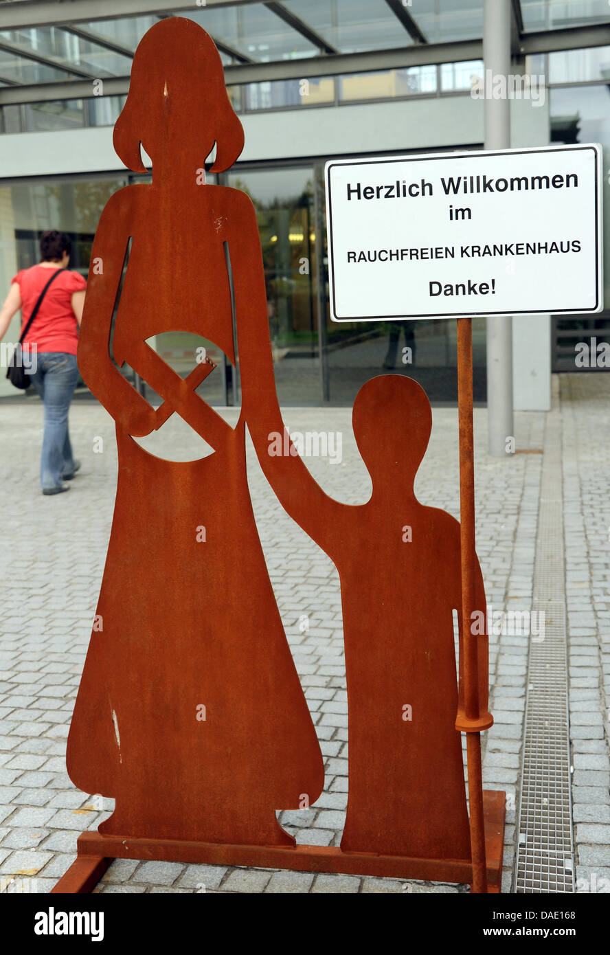 Una donna cammina davanti ad una lettura del segno "Benvenuti al fumo-ospedale gratuito. Grazie!" presso il Park Hospital Clinic per bambini e adolescenti, psichiatria e psicosomatica psicoterapia a Leipzig, Germania, 05 ottobre 2011. Un ricoverato la terapia è stata offerta per computer e internet addicted i bambini e giovani per un paio di mesi. Gli obiettivi del trattamento sono controllati contatto e ragionevole Foto Stock