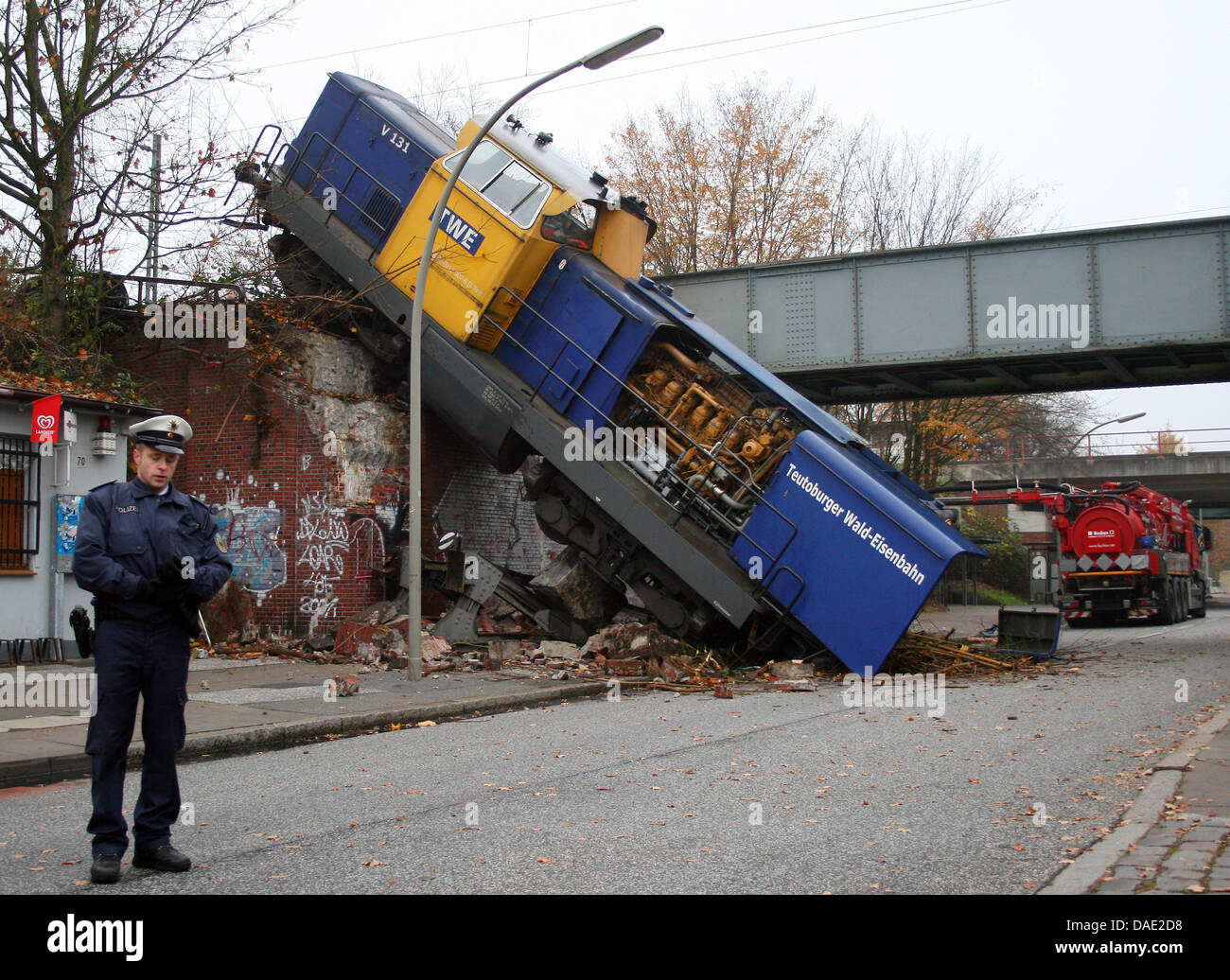 Un treno diesel motore giace deragliato su una pendenza in Amburgo, Germania, 11 novembre 2011. Il motore è deragliato durante una procedura di commutazione, smashing contro un tampone di arresto e plummeting verso il basso a 7 metro di profondità pendenza. Nessun popolo è stato ferito in un incidente. Foto: Daniel Bockwoldt Foto Stock