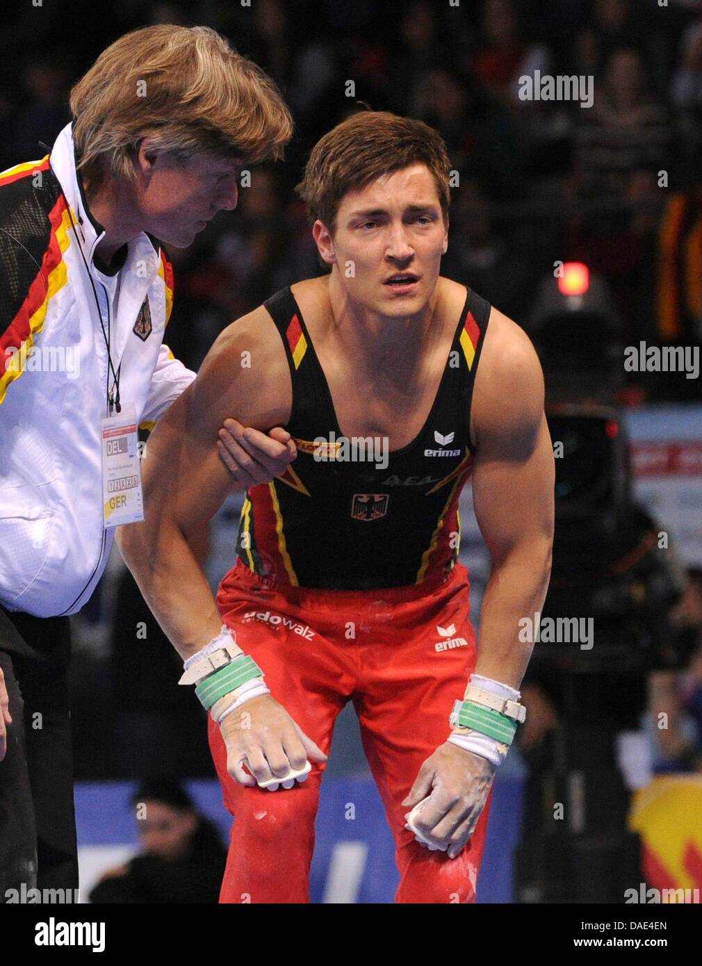 Atleta tedesco Philipp Boy è supportata dopo che è caduto fuori della barra durante la Gymnastics World Cup alla Porsche Arena di Stoccarda, Germania, 13 novembre 2011. Foto: MARIJAN MURAT Foto Stock