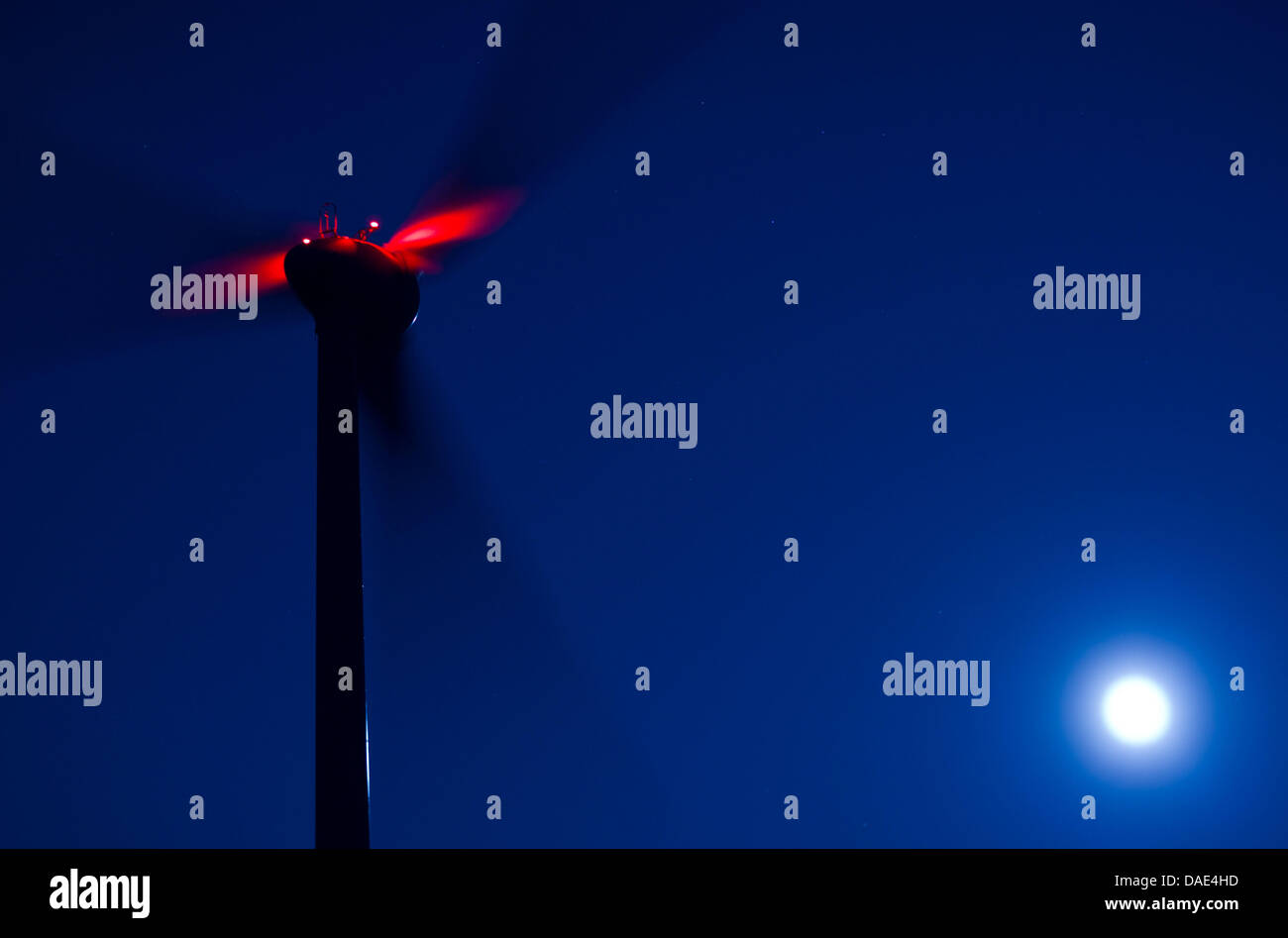 Una turbina eolica con una luce d'ingombro rossa si trasforma in un parco eolico vicino Kladrum, Germania, 10 novembre 2011. La rotazione dei rotori può difficilmente essere visto a causa del lungo tempo di esposizione, solo la luce rossa di riflessioni può essere visto. A causa dell'assenza di linee di potenza e la minaccia della griglia di alimentazione sovraccarico, più e più parchi eolici devono essere obbligatoriamente spenti. La arresti hanno quasi fare Foto Stock