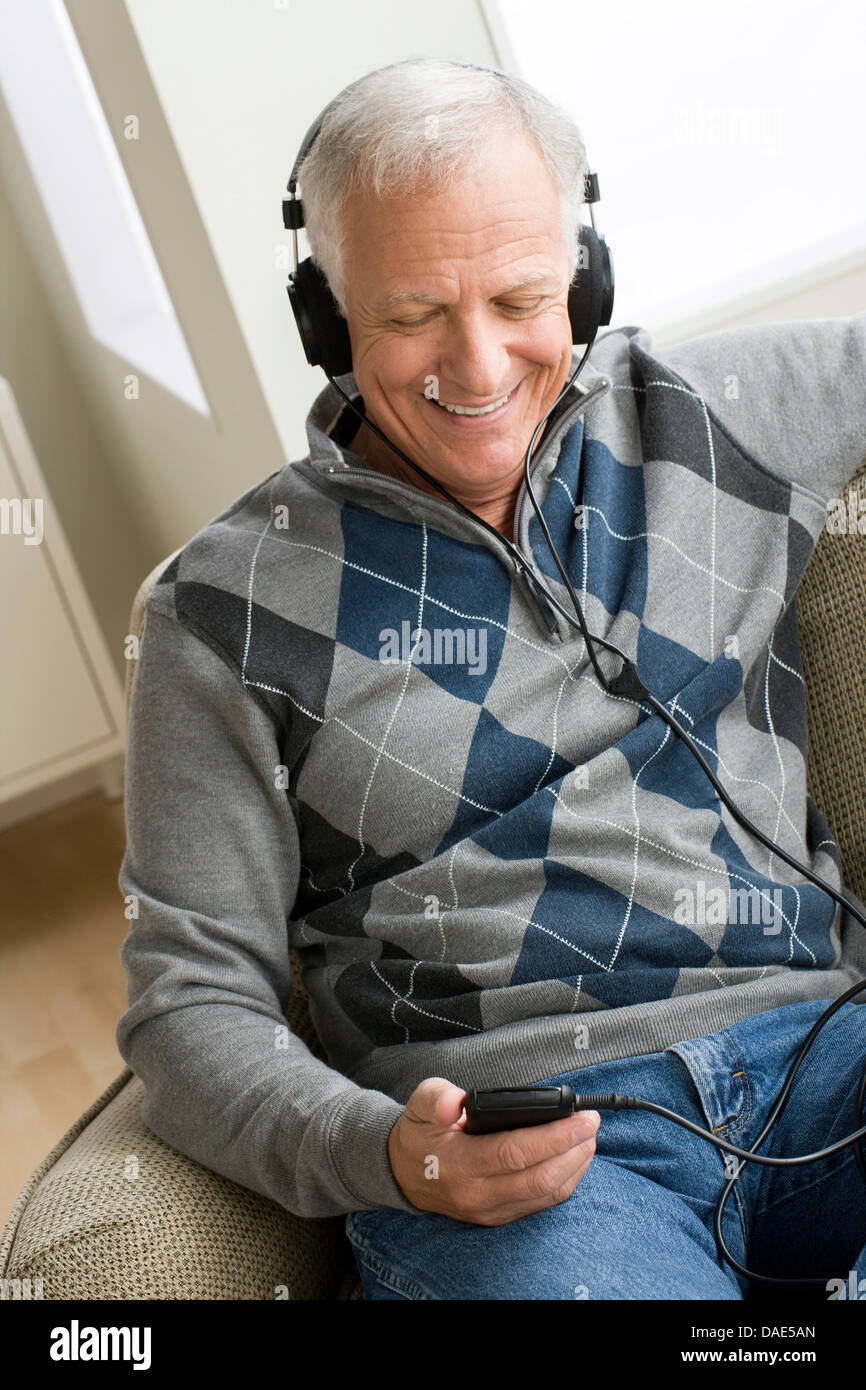 Senior uomo che indossa le cuffie per ascoltare musica Foto Stock