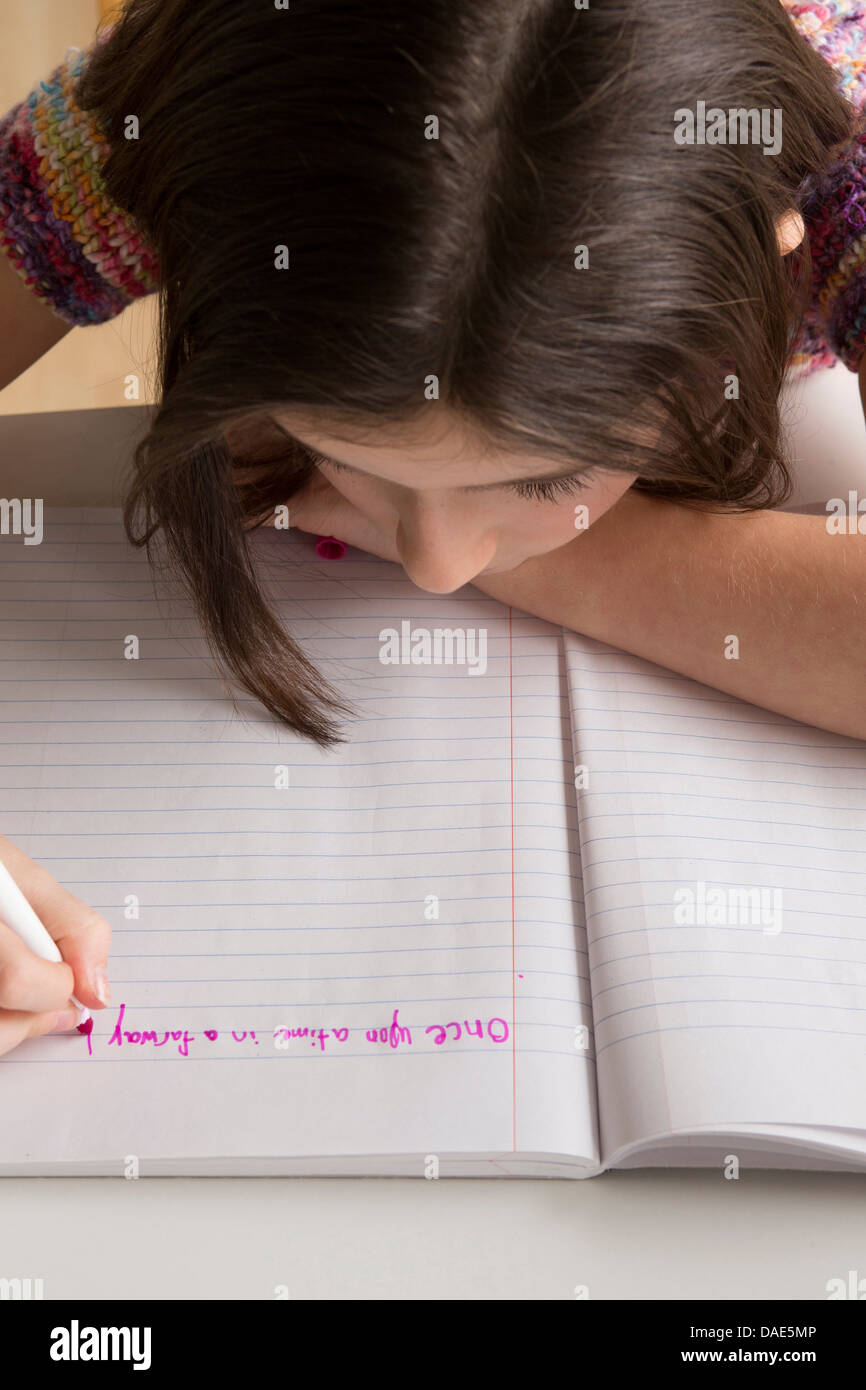 Ragazza la scrittura in rosa pennarello in notebook Foto Stock