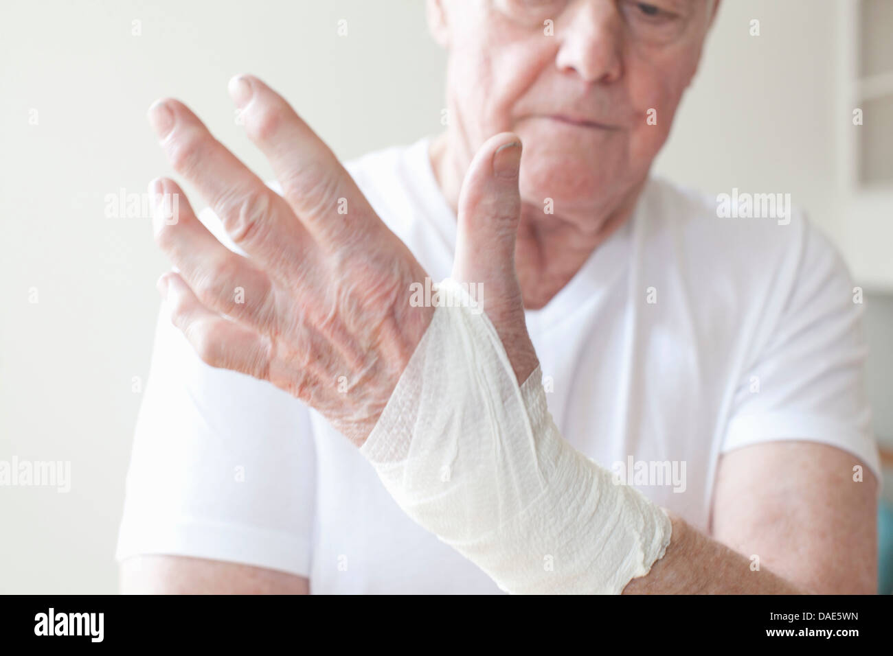 L'uomo anziano con bendaggio al polso Foto Stock