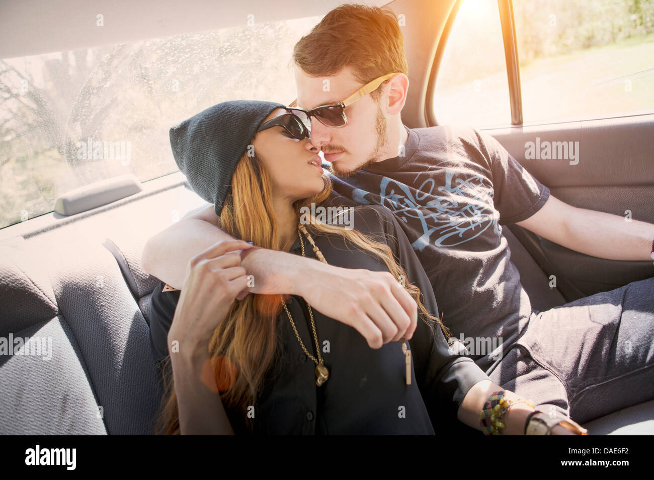 Giovane su backseat in auto, kissing Foto Stock